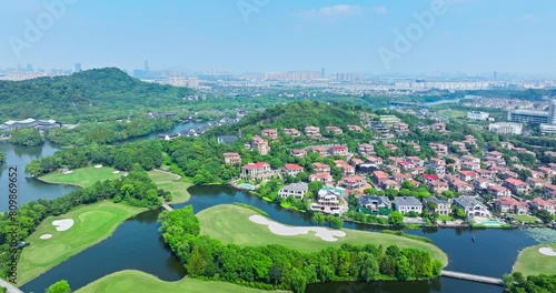 Aerial view of green golf course and residential buildings scenery in Shaoxing, China. golf course and river with buildings landscape in summer. photo