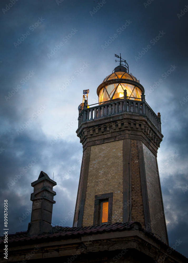 Obraz premium Aviles lighthouse at night with the light on and from very close. Asturias, Spain.