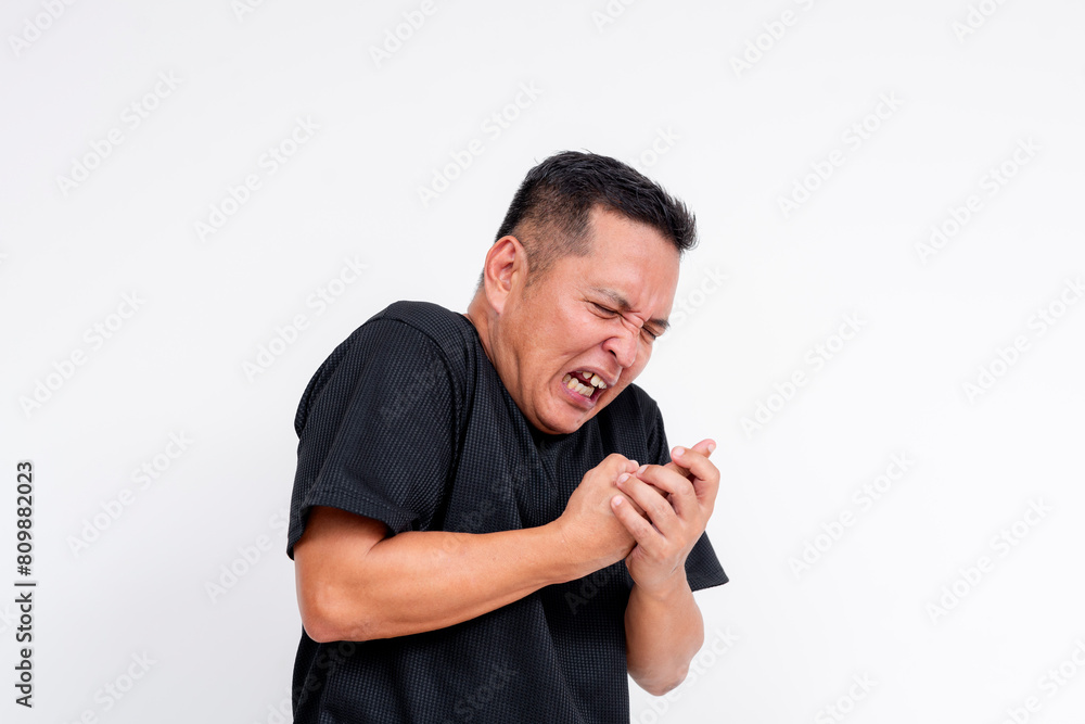 Middle aged Asian man experiencing pain from a finger injury, isolated on white Middle aged Asian man experiencing pain from a finger injury, isolated on white
