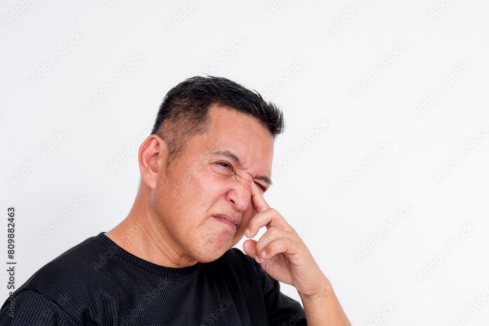 Image of a middle aged Asian man expressing discomfort while rubbing his irritated eyes, isolated on a white background. Image of a middle aged Asian man expressing discomfort while rubbing his irritated eyes, isolated on a white background.
