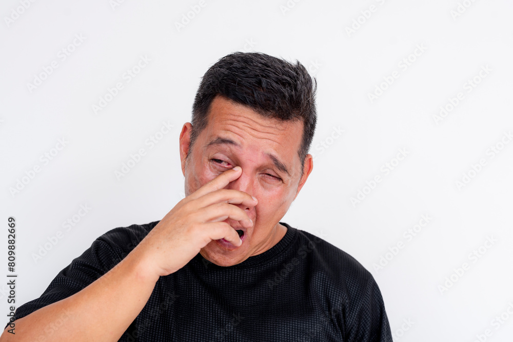 Middle aged Asian man rubbing irritated eyes, isolated on white Middle aged Asian man rubbing irritated eyes, isolated on white