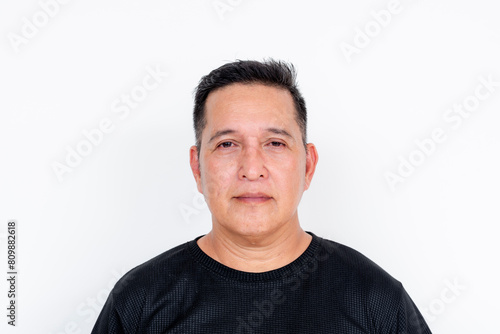 Stoic middle-aged man in a black shirt on a white background, portrait