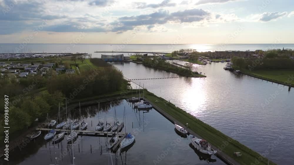 Aerial drone view of lock complex in Frisian city of Stavoren. Large pumping station beside bridge and sluice and historic town with canal, lake, and waterways Aerial drone view of lock complex in Frisian city of Stavoren. Large pumping station beside bridge and sluice and historic town with canal, lake, and waterways