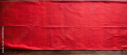 Obraz na płótnie An old wooden table is shown from above with a vibrant red tablecloth leaving an empty space for adding an image. Creative banner. Copyspace image w salonie