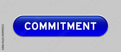 Blue color capsule shape button with word commitment on gray background