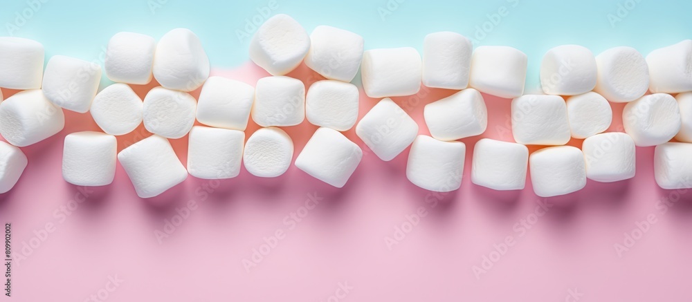Marshmallows arranged in a flat lay composition with a copy space frame on a pastel pink and blue background Minimal yet creative concept Marshmallows arranged in a flat lay composition with a copy space frame on a pastel pink and blue background Minimal yet creative concept