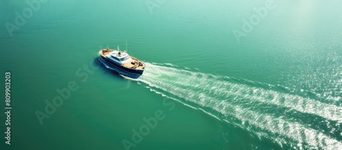 A picturesque aerial view of a boat or tugboat peacefully gliding on the captivating green blue river water adorned with a beautiful texture offering ample copy space