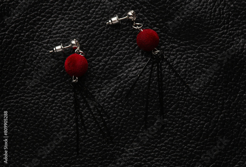 Stylish stud earrings on black leather background © splitov27