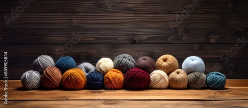 An image of balls of wool placed on a wooden table with a weathered appearance is available with blank space for copy. Creative banner. Copyspace image