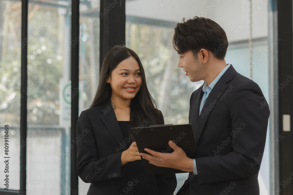 two employees are talking about an information of meeting report, colleagues are discussing and giving some advice to each other, happy workplace atmosphere, working together. two employees are talking about an information of meeting report, colleagues are discussing and giving some advice to each other, happy workplace atmosphere, working together.