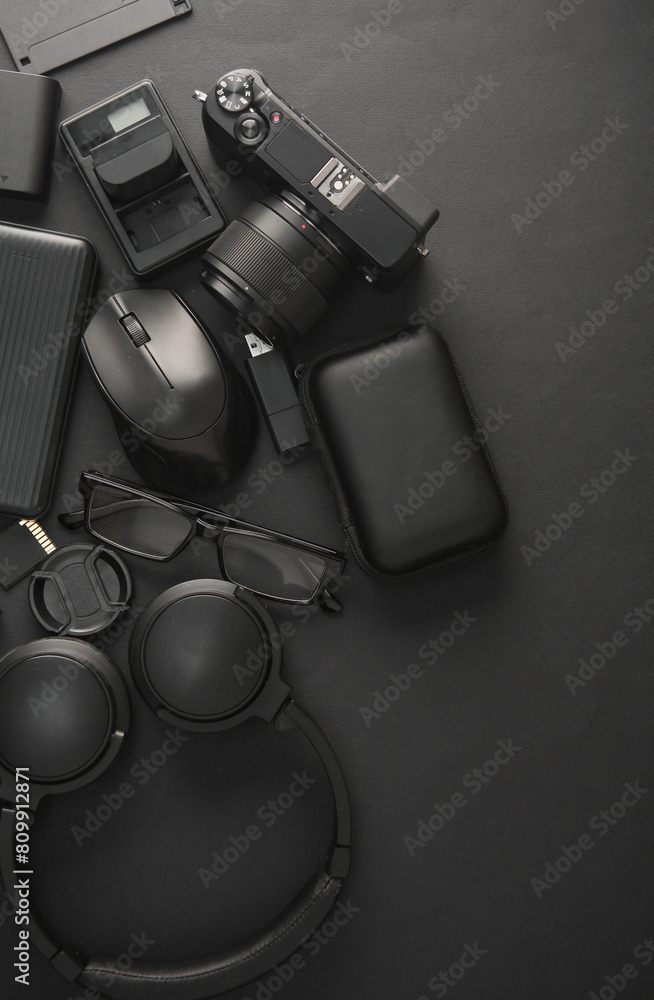 Naklejka premium Flat lay composition of Modern black gadgets and accessories on dark black background. Top view.