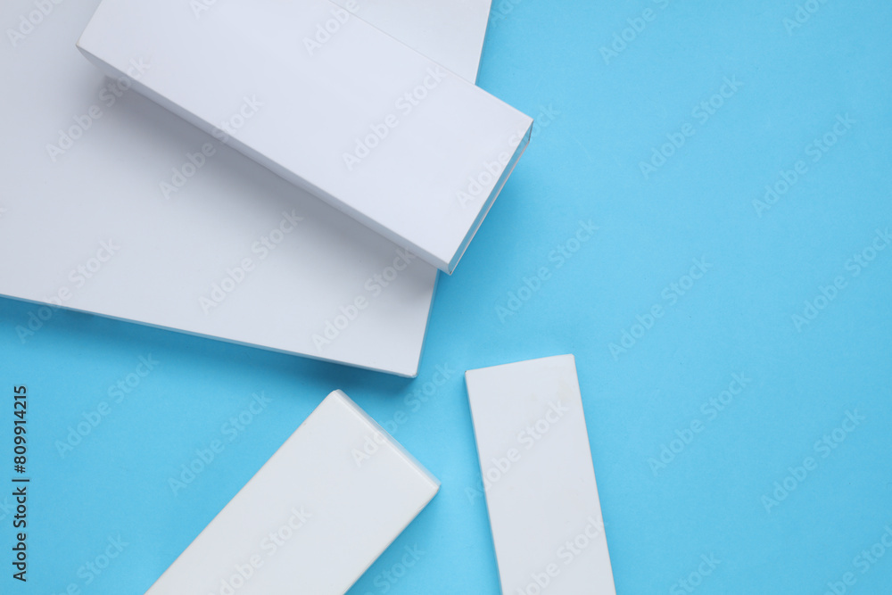 Different shapes of white cardboard boxes for products on blue background. Mockup for design Different shapes of white cardboard boxes for products on blue background. Mockup for design
