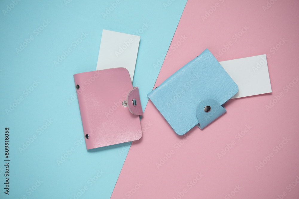 Leather business card holders with white blank business cards on a blue pink background. Top view Leather business card holders with white blank business cards on a blue pink background. Top view