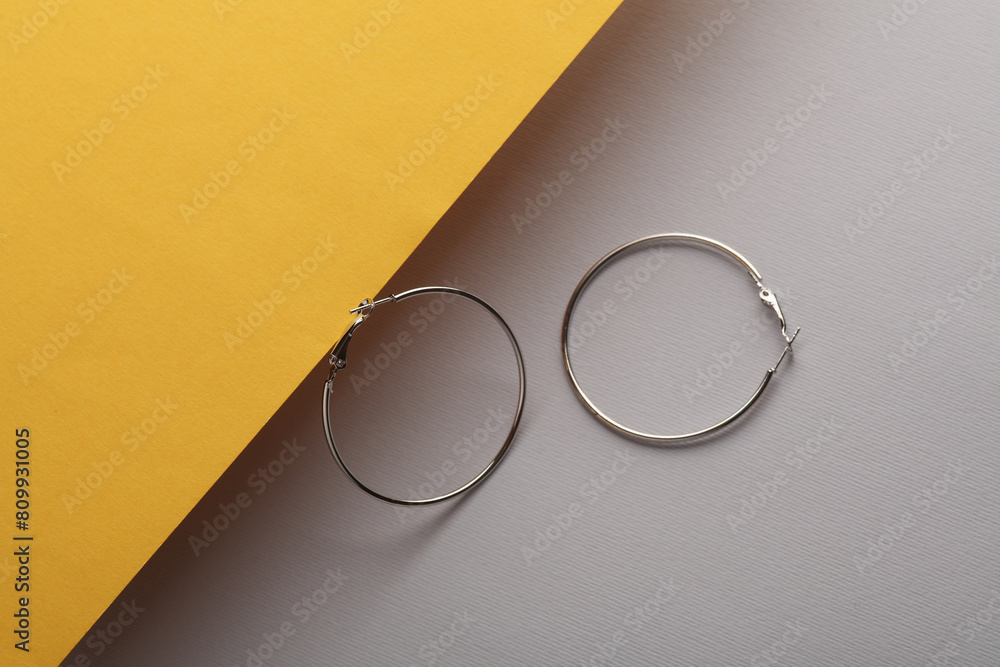 Silver ring earrings on a yellow gray background Silver ring earrings on a yellow gray background