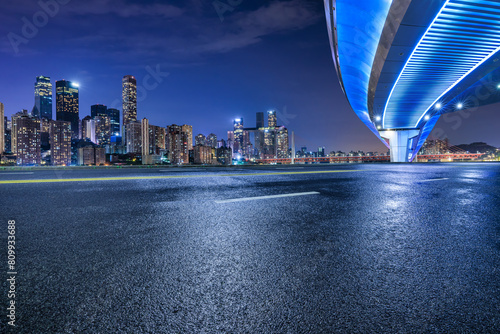 Asphalt highway road and bridge with modern city buildings at night in Chongqing