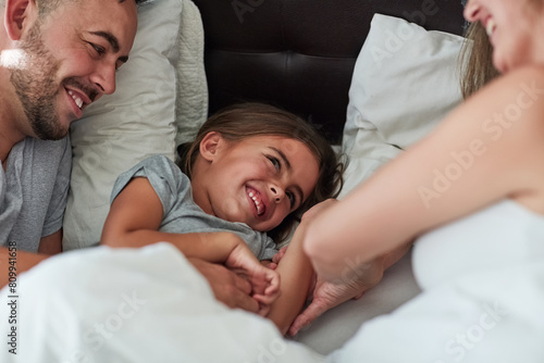 Love  laughter and happy family in bed for tickle fun  playing or bonding at home together. Support  security and girl with funny parents in bedroom for wake up games with safety  care or protection