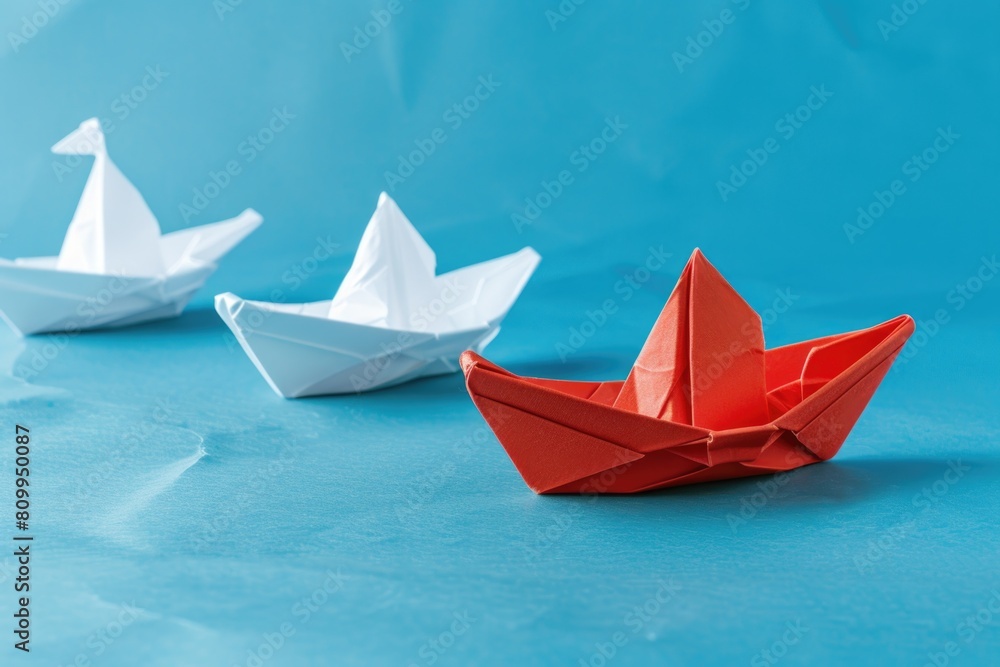 Row of origami boats on blue surface, ideal for nautical themed designs Row of origami boats on blue surface, ideal for nautical themed designs