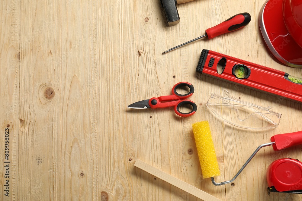 Flat lay composition with building level and other different construction tools on wooden background, space for text