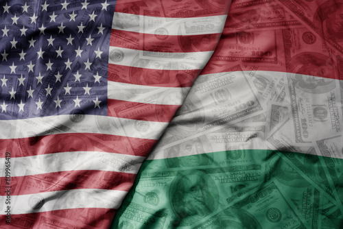 big waving colorful flag of united states of america and national flag of hungary on the dollar money background. finance concept. photo