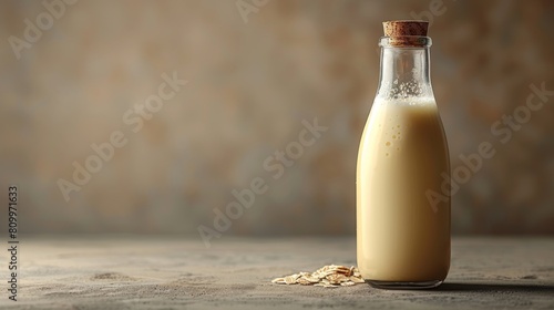 Fresh oat milk in glass bottle on neutral background