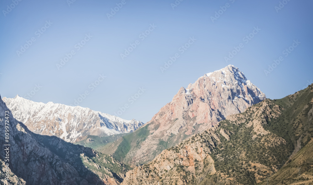 Rocky peaks of mountains and ridges with snow on an early sunny morning Rocky peaks of mountains and ridges with snow on an early sunny morning