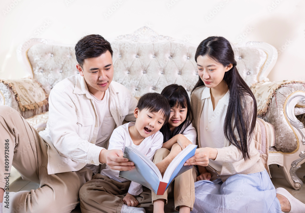 A family of four reading and playing together in the living room A family of four reading and playing together in the living room