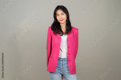 portrait of happy asian business woman wearing pink suit on isolated background