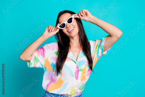 Photo of positive cheerful nice woman wear stylish print clothes sunglass dance enjoy weekend isolated on cyan color background