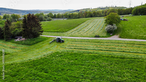 Ein Landwirt wendet mit Traktor das abgemähte Gras (Luftaufnahme) photo