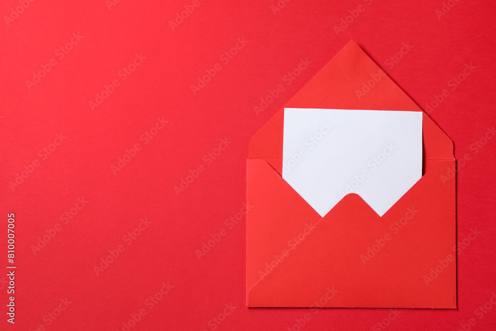 Letter envelope with card on red background, top view. Space for text