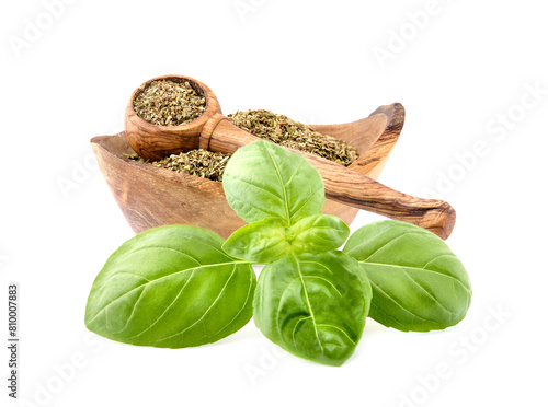Basil leaves in closeup on white background. Basil Spice in wooden spoon .