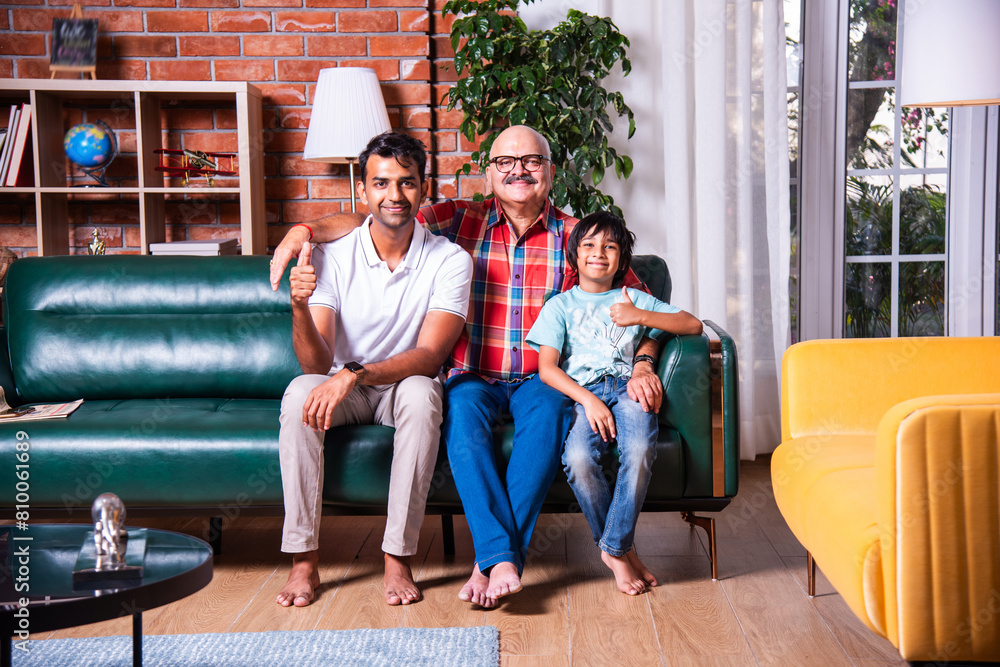 Indian multigenerational family, kid, father and grandfather sitting on sofa