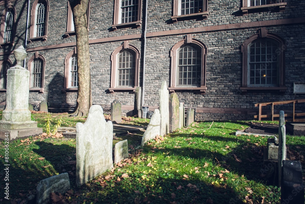 Fototapeta premium A cemetery with a large stone building in the background