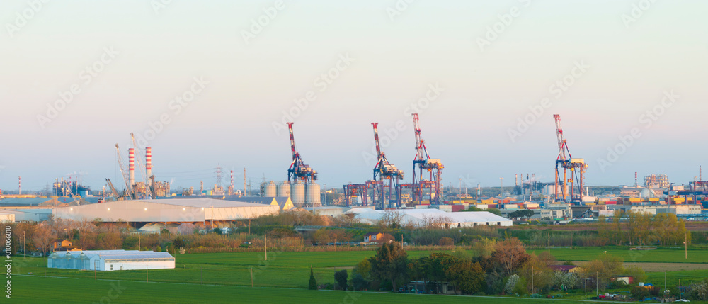 Fototapeta premium Aerial view of the industrial and port area of Ravenna ,chemical and petrochemical pole,thermoelectric,metallurgical plants and hydrocarbon refinery and liquefied natural gas tanks