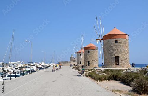 a road with windmills and boats on the side copy space 