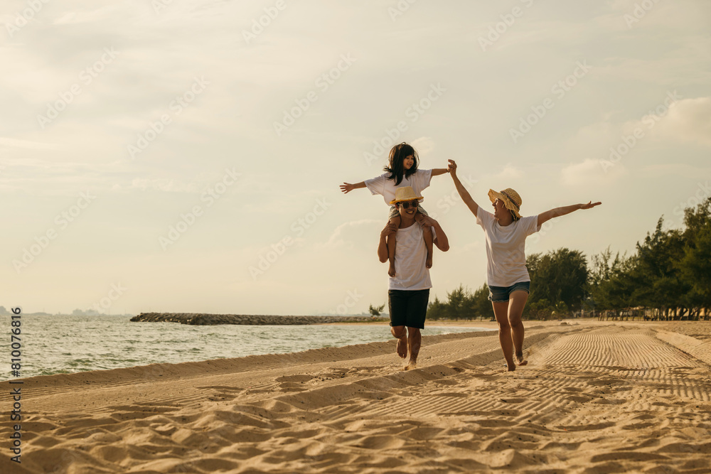 Road trips day. Happy family people having fun in summer vacation on beach, daughter riding on father back and mother running race at sand beach, enjoying road family trip playing together outdoor Road trips day. Happy family people having fun in summer vacation on beach, daughter riding on father back and mother running race at sand beach, enjoying road family trip playing together outdoor