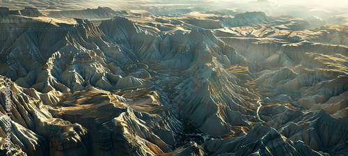 Early morning light casting golden hues over the rugged terrain of the badlands, with deep gullies and sharp ridges in the foreground photo