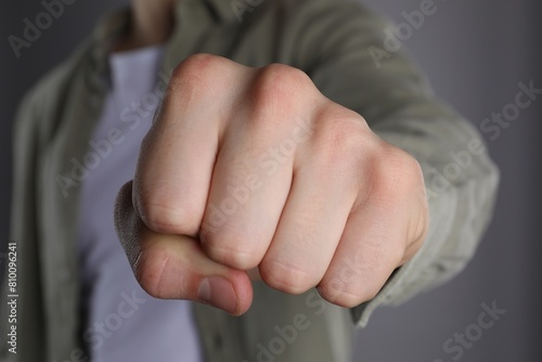 фотографія Man showing fist with space for tattoo on grey background, selective focus