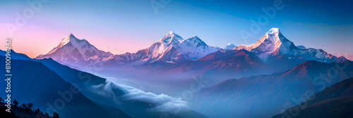 Majestic view of snow-capped mountains with a clear tropospheric sky transitioning from golden hour to blue hour photo