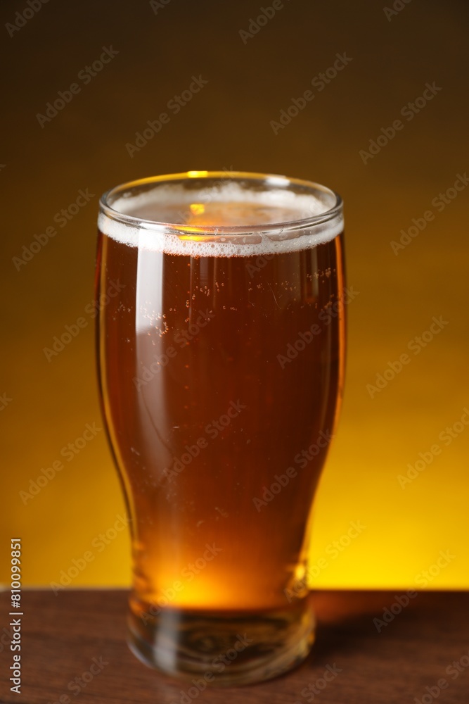 Glass with fresh beer on wooden table against dark background, closeup Glass with fresh beer on wooden table against dark background, closeup