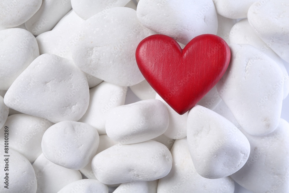 Obraz premium Decorative heart on white pebble stones, top view