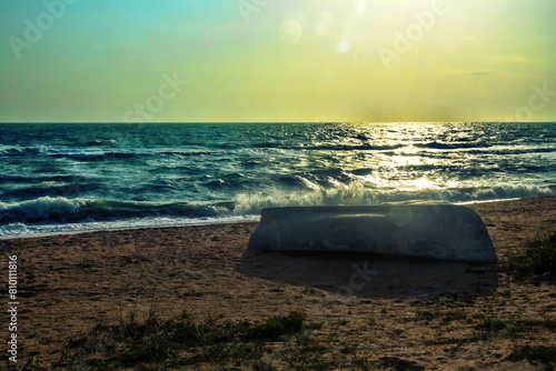 The Sea of Azov in a storm, ground swell. A fishing boat on the shore is overturned. Arabatskaya strelka photo