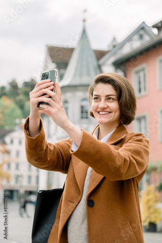 Woman taking selfie while visiting the downtown of a city