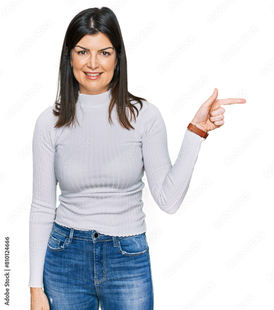 Beautiful brunette woman wearing casual clothes with a big smile on face, pointing with hand finger to the side looking at the camera. Beautiful brunette woman wearing casual clothes with a big smile on face, pointing with hand finger to the side looking at the camera.
