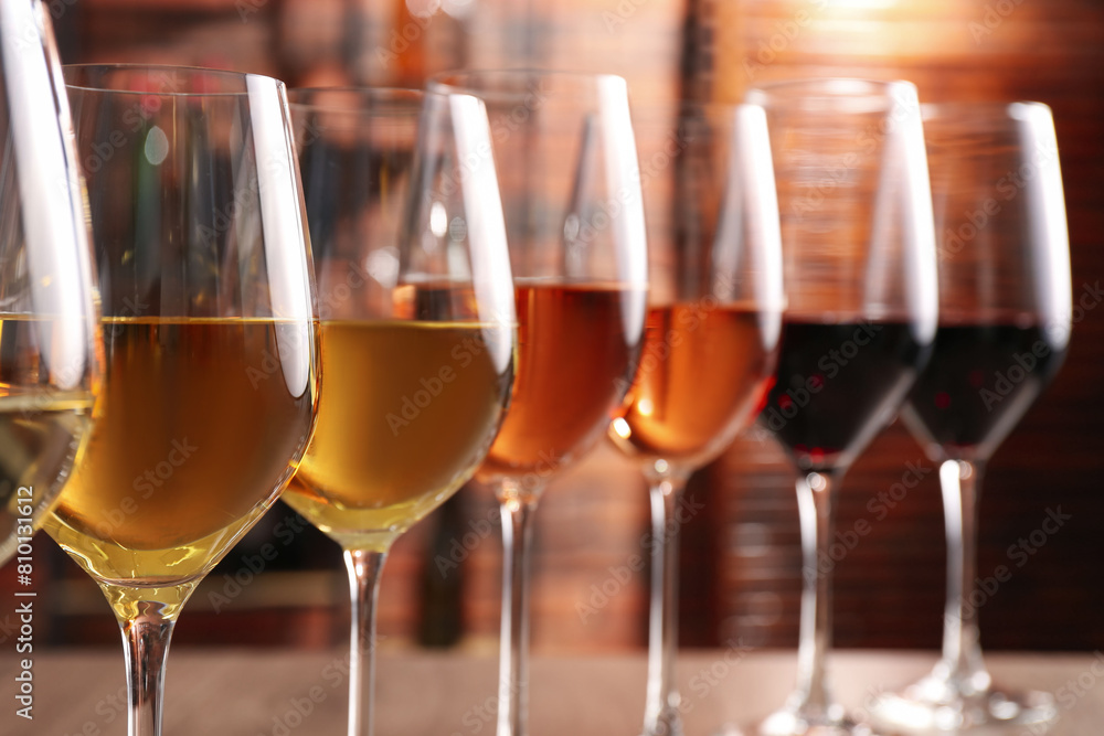 Different tasty wines in glasses against blurred background Different tasty wines in glasses against blurred background