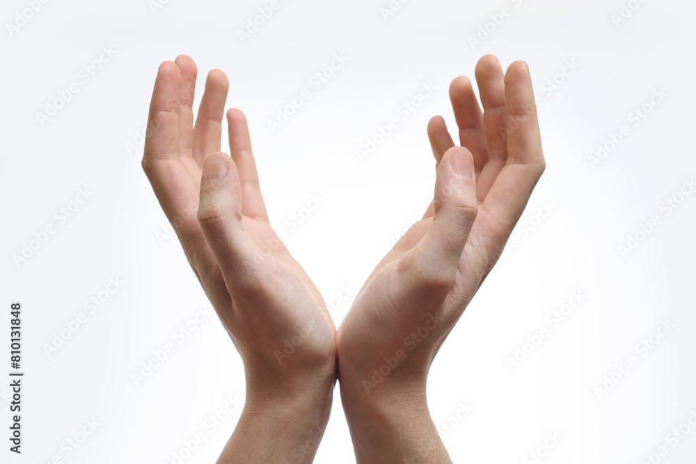 Man holding something in hands on white background, closeup Man holding something in hands on white background, closeup
