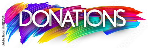 Donations paper word sign with colorful spectrum paint brush strokes over white.