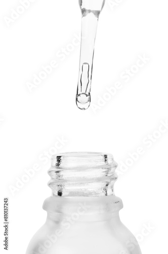 Dripping liquid from pipette into bottle isolated on white, closeup