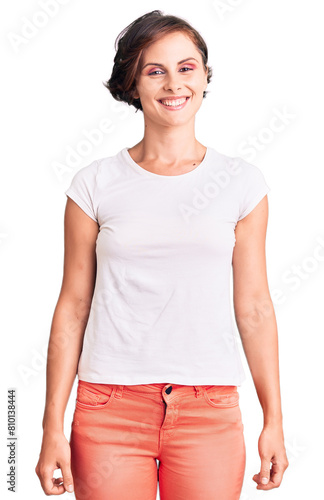 Beautiful young woman with short hair wearing casual clothes looking positive and happy standing and smiling with a confident smile showing teeth