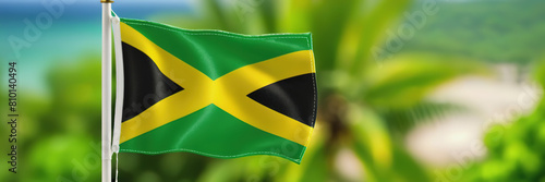 The waving flag of Jamaica against the background of the nature of Jamaica. Jamaica's Independence Day